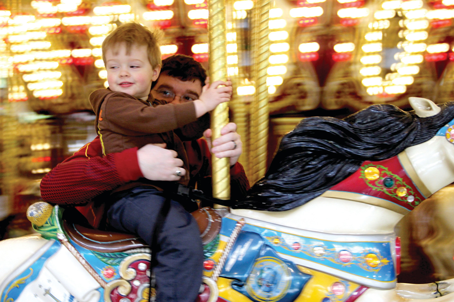 PART OF THE FUN: With his father Joshua holding on Silas Davis takes a spin on the carousel.